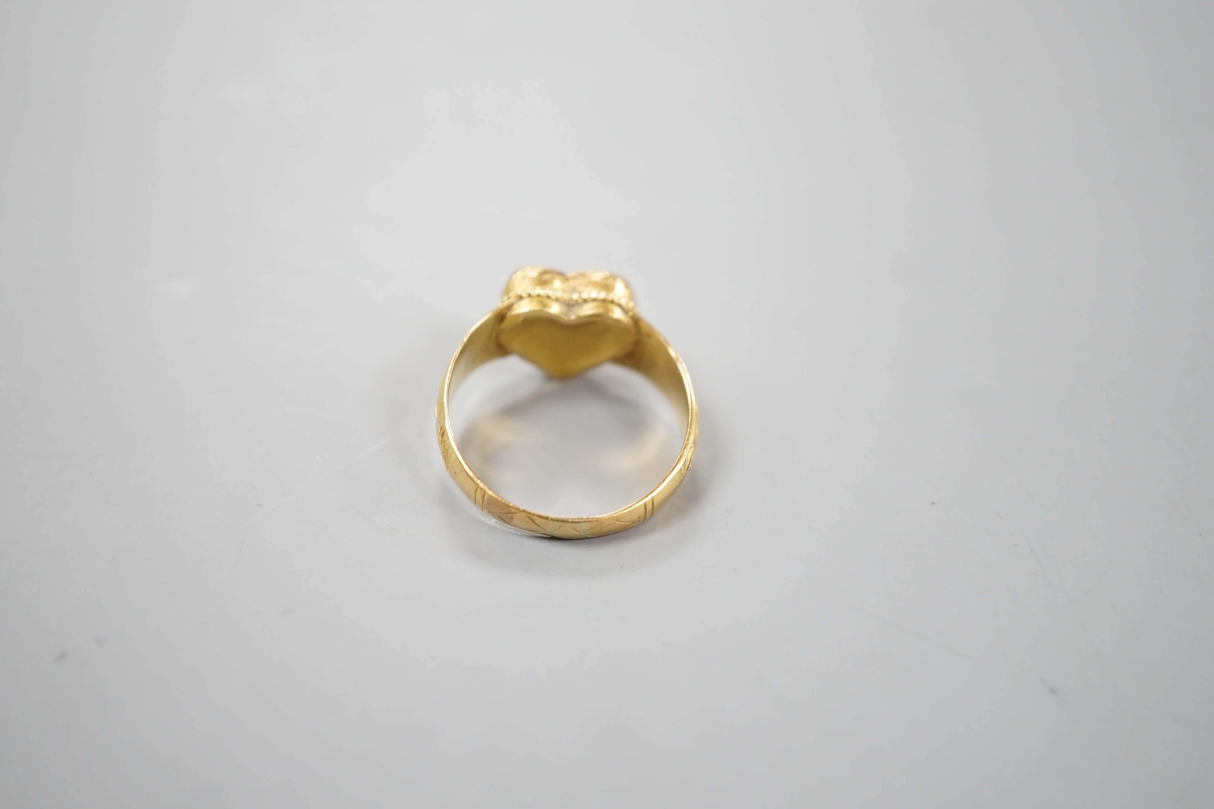 An Indian yellow metal and heart shaped diamond set ring, with engraved shank, size O, gross weight 6.2 grams, (crack to stone).